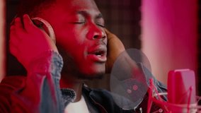 Emotional Black Guy Wearing Headphones Singing To Professional Microphone In Music Studio With Red Lighting, Talented African American Male Singer Recording New Song, Slow Motion Footage - Powered by Shutterstock - Get 15% off with code: PIKWIZARD15