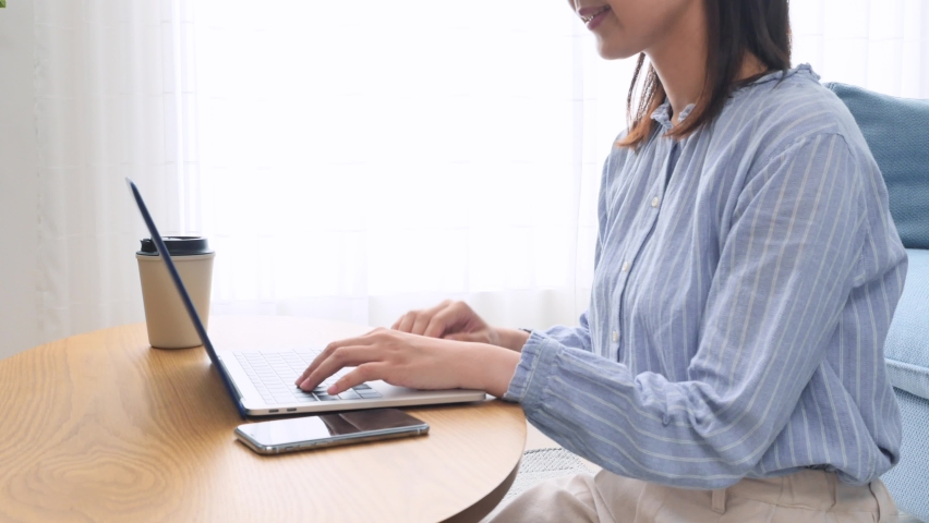 Asian woman using the laptop at home, no face