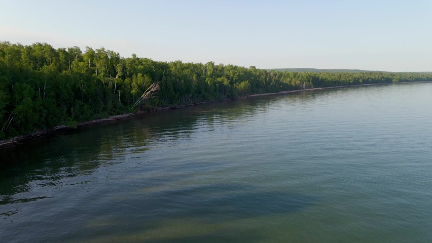 Aerial view of a beautiful forest by lake shore on a summer golden hour. Myers beach at Apostolate island National seashore, Lake Superior Wisconsin