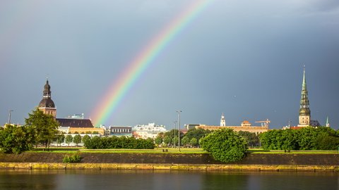 Time lapse shot of beautiful rainbow over Riga City during cloudy day,Latvia - Beautiful churches,Daugava river and driving cars on road