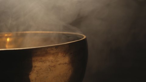The Tibetan singing bowl is musical, the hand strikes with a stick on the bowl.
