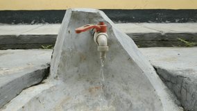Water Dripping From The building faucet Tap. in the video you can see the water flowing smoothly
