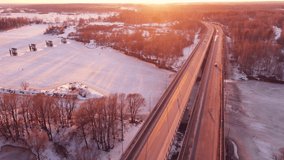 Beautiful winter landscape with a road bridge at sunset, aerial view. The ground is covered with white snow. Video, footage, splash screen, intro, presentation, copy space. UHD 4K.