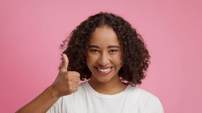 I Like It. Cheerful Black Woman Gesturing Thumbs Up With Both Hands Smiling To Camera Over Pink Background In Studio. Portrait Of Female Approving Something With Thumbs-Up Gesture