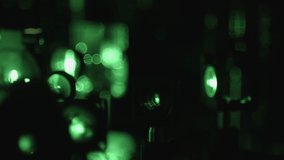 This stock video shows a scientific experiment with green laser beams that pass through lenses. This video will decorate your projects.