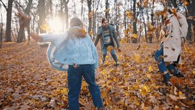 Young mom, dad and little daughter in casual clothes laughing and throwing yellow leaves at each other, playing in autumn park. Sunny day. Happy family, trusting relationship. Slow motion, dolly shot - Powered by Shutterstock - Get 15% off with code: PIKWIZARD15