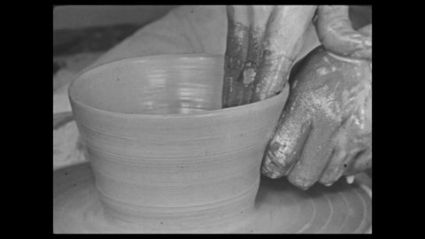 1940s: Painting. Man shapes clay on potters wheel. Man puts piece of pottery on shelf. Pot in kiln.