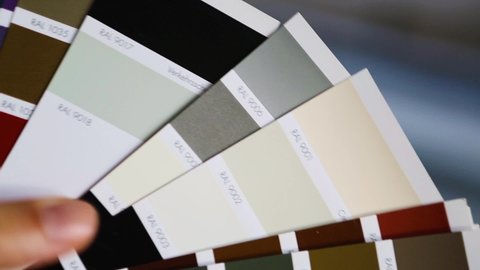 Selection of the paint color for laminated window frame to the palette with layouts of the RAL company Tikkurila. Repair and construction, covering of small chips. October 29, 2021, Kaluga, Russia