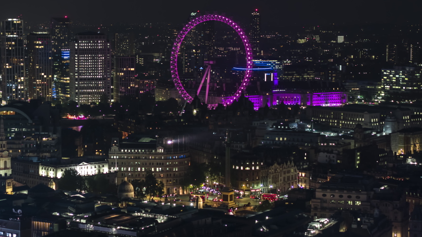 London, Great Britain - circa 2021 - Establishing Aerial View Shot of London UK, London Eye, United Kingdom, city at night evening, lit up landmarks
