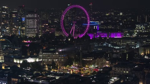 London, Great Britain - circa 2021 - Establishing Aerial View Shot of London UK, London Eye, United Kingdom, city at night evening, lit up landmarks