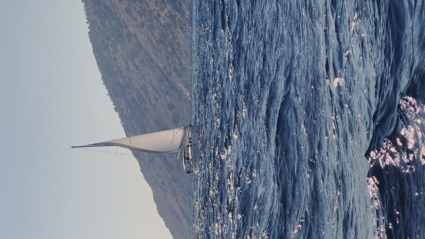 The picturesque seascape near the many islands near Marmaris, participants of the sailing regatta on the boat, mountains on background