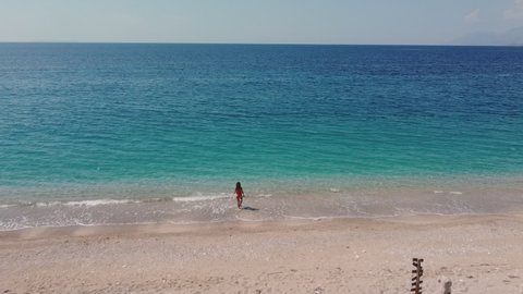 Drone air. Woman walking on beach.
Albania. Ionic Sea, Turquoise Water. Albanian Tourism.