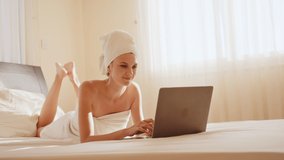 Happy girl, gen z teen girl video calling on laptop at home. Teenager having online virtual social distance videocall chatting with friend using computer lying on bed in bedroom