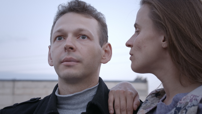 Video of couple sitting on the brick roof, smoker man