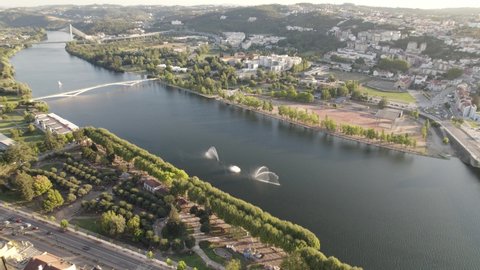 Panoramic aerial view of Mondego river and reveal of Coimbra buildings.