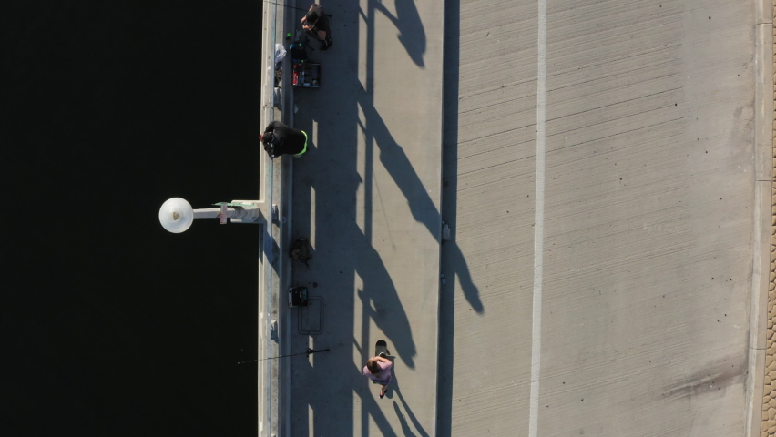 Person skateboarding on coastal asphalt sideway and road, top down aerial view