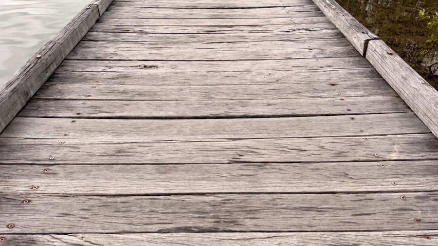 An interesting pan view of the scenery along a wooden boardwalk designed to get close to the mangrove forests located next to a large coastal river on the east coast of Australia.