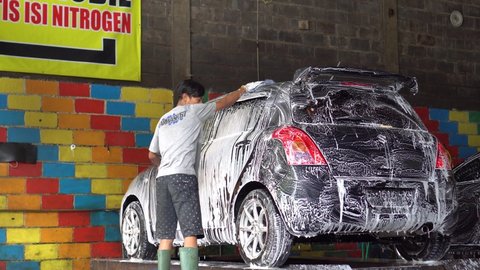 Malang, Indonesia, 28 nov 2021: man washing the car at the car wash