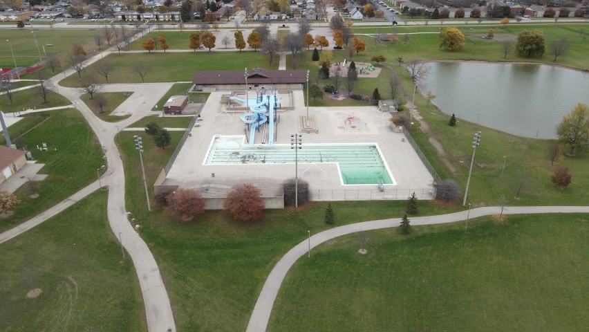 Anderson Park, Kenosha, Wisconsin, drone view of entire complex. Autumn leaves and trees shown.  Fence around perimeter.  Pond seen in corner. Trails for hiking and biking. 