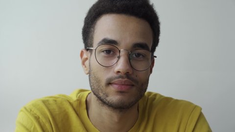 Portrait of an African-American young man with glasses.. Looking at the camera.