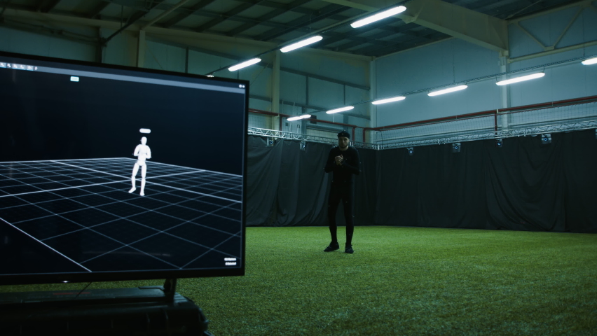 BTS of game industry - Actor in motion capture suit performing some stunt moves as a game character. Motion capture is an unparalleled method for making animated characters move more realistically Royalty-Free Stock Footage #1083193570