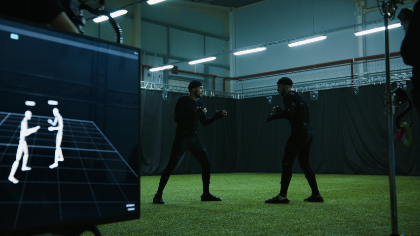 Cameraman filming actors performing some fight moves wearing motion capture suits as a game characters. Motion capture is an unparalleled method for making animated characters move more realistically Royalty-Free Stock Footage #1083193582