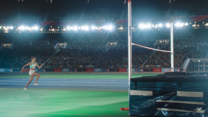High Jump Championship: Professional Female Athlete Running, Successfully Jumping over Bar. Happy Sportswoman Celebrates Winning with Stadium Full of Spectators Cheering. Cinematic, Slow Motion Royalty-Free Stock Footage #1083194926