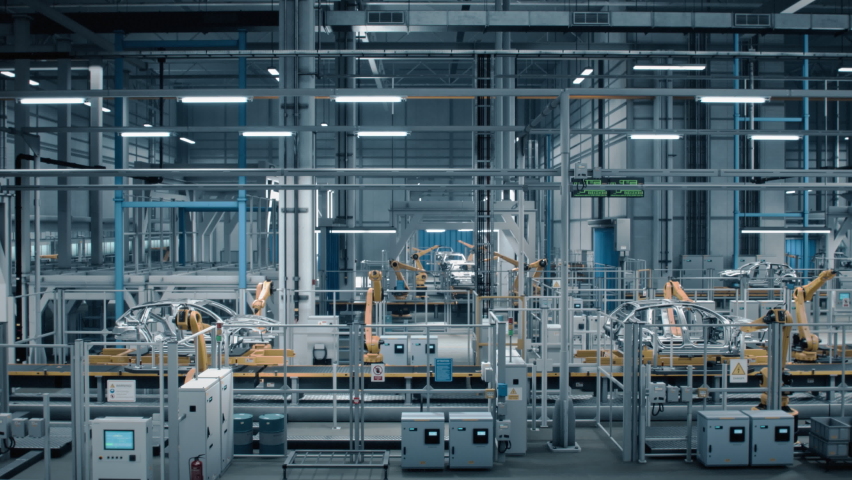 Side-View Car Factory Digitalization: Automated Robot Arm Assembly Line Manufacturing High-Tech Sustainable Electric Vehicles. Futuristic AI Computer Vision Analyzing, Scanning Production Efficiency | Shutterstock HD Video #1083194944