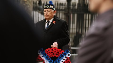LONDON, circa 2021 - A war veteran with a red poppy on the lapel is seen in Whitehall, London, England, UK during the traditional Remembrance Sunday event in Whitehall, London, UK
