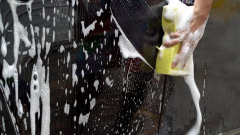 hands hold sponge for washing car