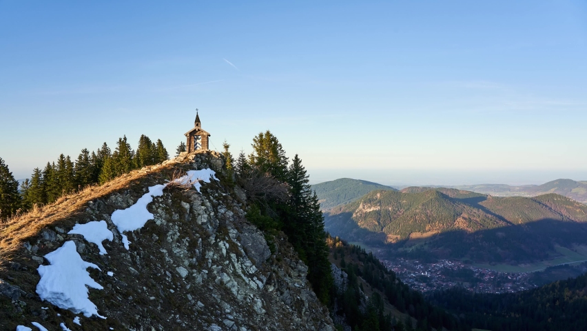 Golden hour timelapse of the Freudenreich chapel on the ridge of Brecherspitz, a famous hiking destination in the mountains of the alps in Bavaria, Germany