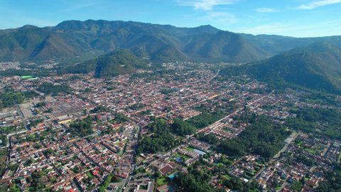 Antigua, Guatemala. Panoramic view of Central American UNESCO town surrounded by mountains. 4K Drone.