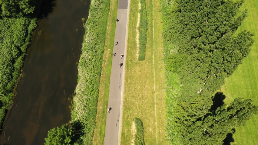 Aerial view of bicyclist on a long road hidden by trees
