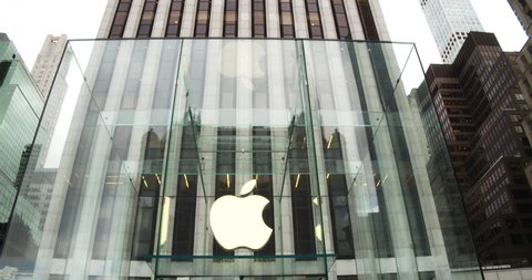 New York, New York United States - November 15,  2021: The famous glass entrance to Apples's Flagship store in NYC. Pan down from building to reveal Apple Logo.
