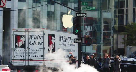 New York, New York United States - November 15,  2021: Time-laps of city traffic in front of Apple Logo on entrance of Apple's Flagship store on 5th ave.