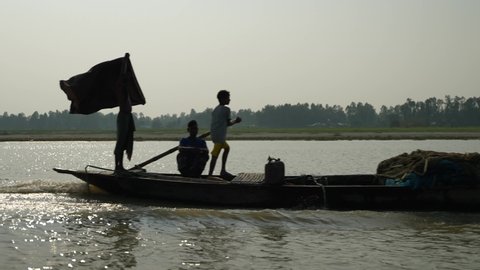 Dhaka, Bangladesh - November 30 2021: A traditional wooden boat with passengers and engine traveling on a river