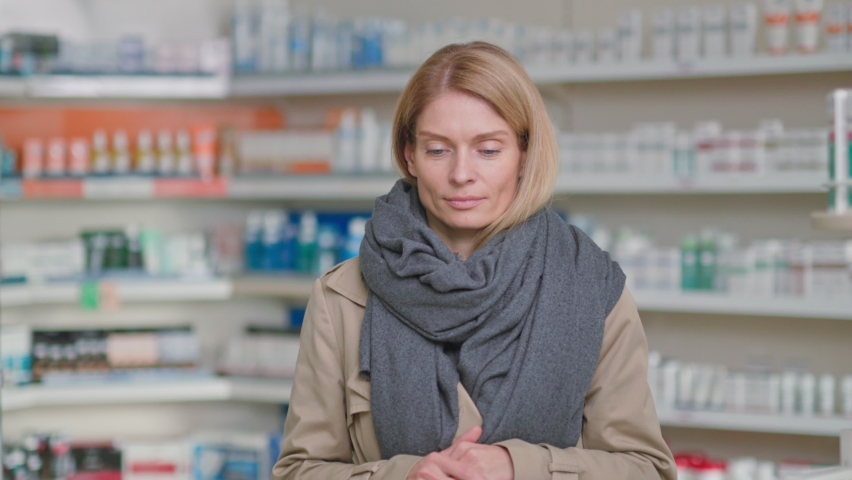 Sick caucasian woman in coat wearing scarf having terrible headache syndrome massaging temples. Virus symptoms. Illness, healthcare. Pharmacy.