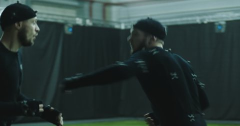 BTS of game industry - Actors in motion capture suits performing some fight moves as a game characters. Motion capture is an unparalleled method for making animated characters move more realistically