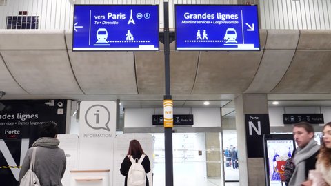 Paris, France - Circa 2019: Busy airport scene with commuters buying train tickets links to Paris-Charles de Gaulle train station platform - signage to Paris direction and Grand lines fast TGv trains