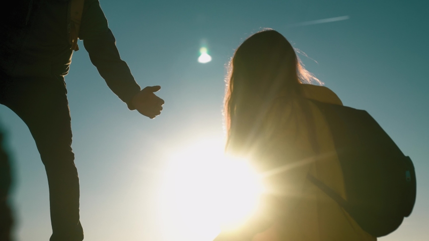 help team concept. couple team silhouette of two climber stretching a helping hand to a friend. business teamwork success concept. sunlight silhouette business travel tourists pull a helping hand Royalty-Free Stock Footage #1083237280