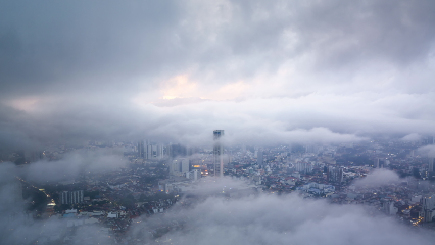 Time lapse of rolling clouds over city of Penang (Pulau Pinang) Malaysia during sunset dusk. Tilt down