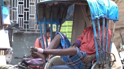 Kanchrapara , West Bengal , India - 11 09 2021: Poor and tired old man relaxing in his rickshaw, Indian rickshaw driver