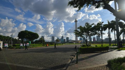 Beautiful thick fluffy clouds over Jakarta National Monument  (Monas). Amazing timelapse of soft white clouds moving slowly on the clear blue sky in pure daylight. (circa 11-2021)