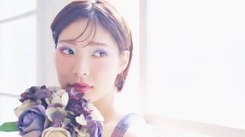 Young Asian woman holding a bouquet. Beauty concept. Skin care. Cosmetics.