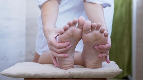 Hands of a Masseur, Therapist are Massaging Bare Feet, Soles of a Child. Pressing acupuncture points of foot with fingers. Reflex massage. Effective treatment, improves blood circulation in soles. 4K.