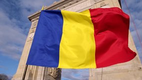 4K Video with the National flag of Romania winding in front of the Arch of Triumph landmark from Bucharest
