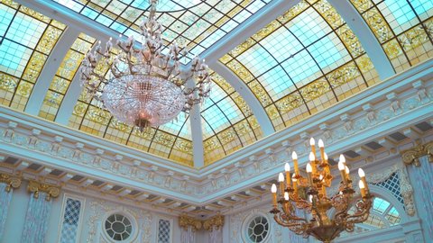 beautiful interior, dolly shot. a huge chandelier on a high glass ceiling and a classic gilded candlestick with warm electric lamps. interior design looks like a royal hall
9.23.2021 Kyiv, Ukraine