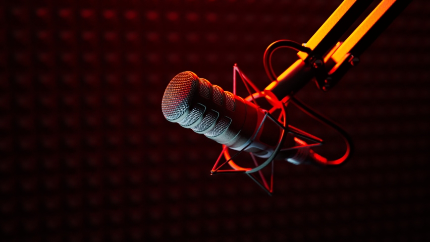 Podcast audio recording. Broadcasting studio. Closeup on a professional microphone in red light coming from red on-air sign in the background. A soft backlight falls on the equipment. Journalism.