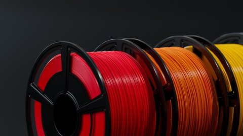 Multicolored filaments spools of plastic. Printing on a 3D printer. 3D printing motley different colors thermoplastic filament. Additive technology. Motley wire plastic for 3d printer. Closeup.