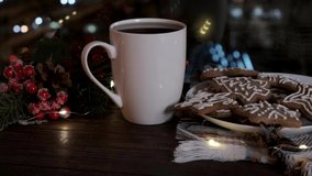Cozy still life with a mug of hot drink, candle and traditional Christmas gingerbread cookies